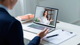 A man from behind having an online conversation with a woman via his computer