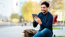 a young man checking things on a small tablet